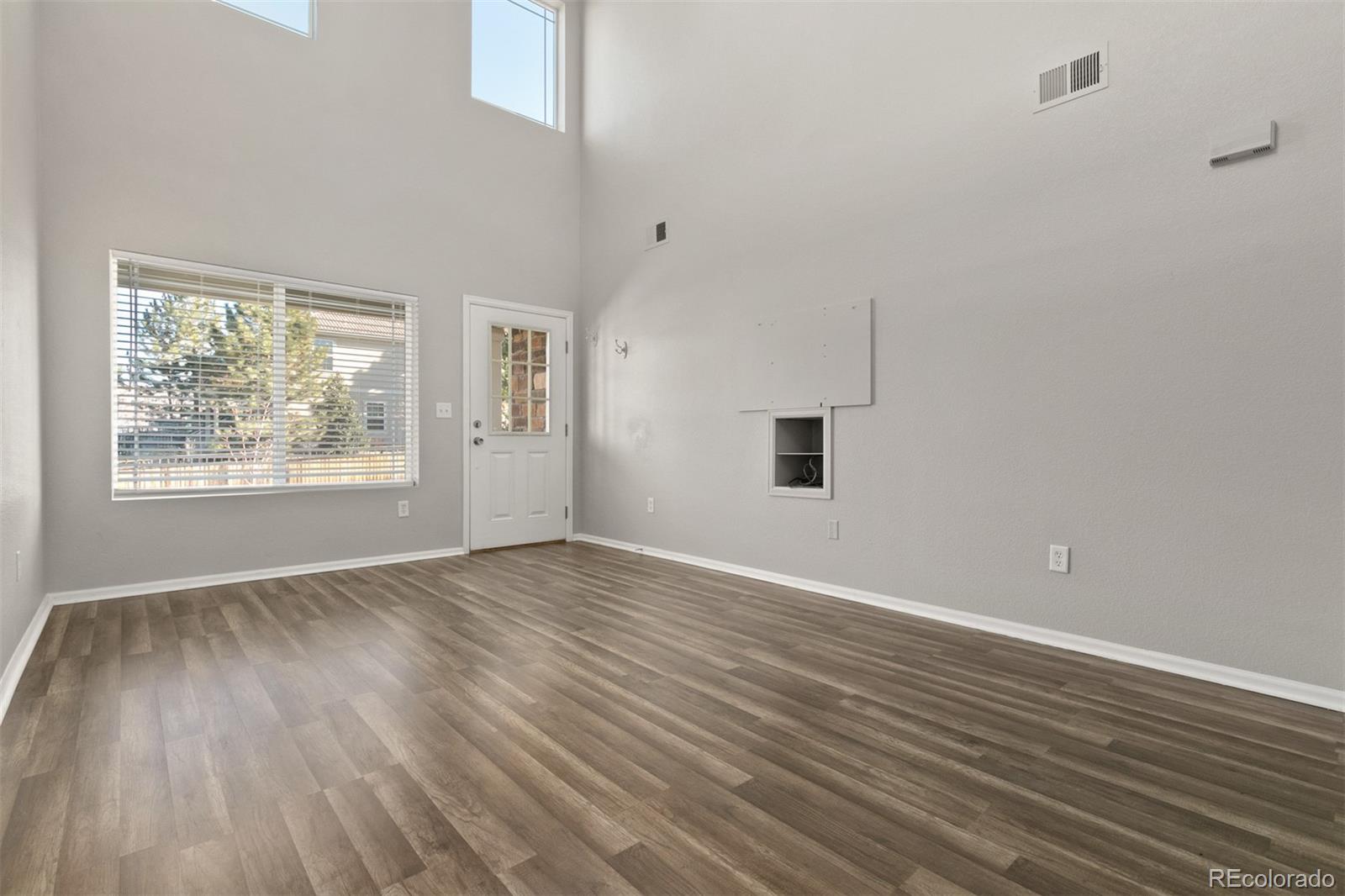 2562 Coach House Loop Castle Rock, CO 80109 - Photo 4 of 20 wooden floor in an empty room with a window