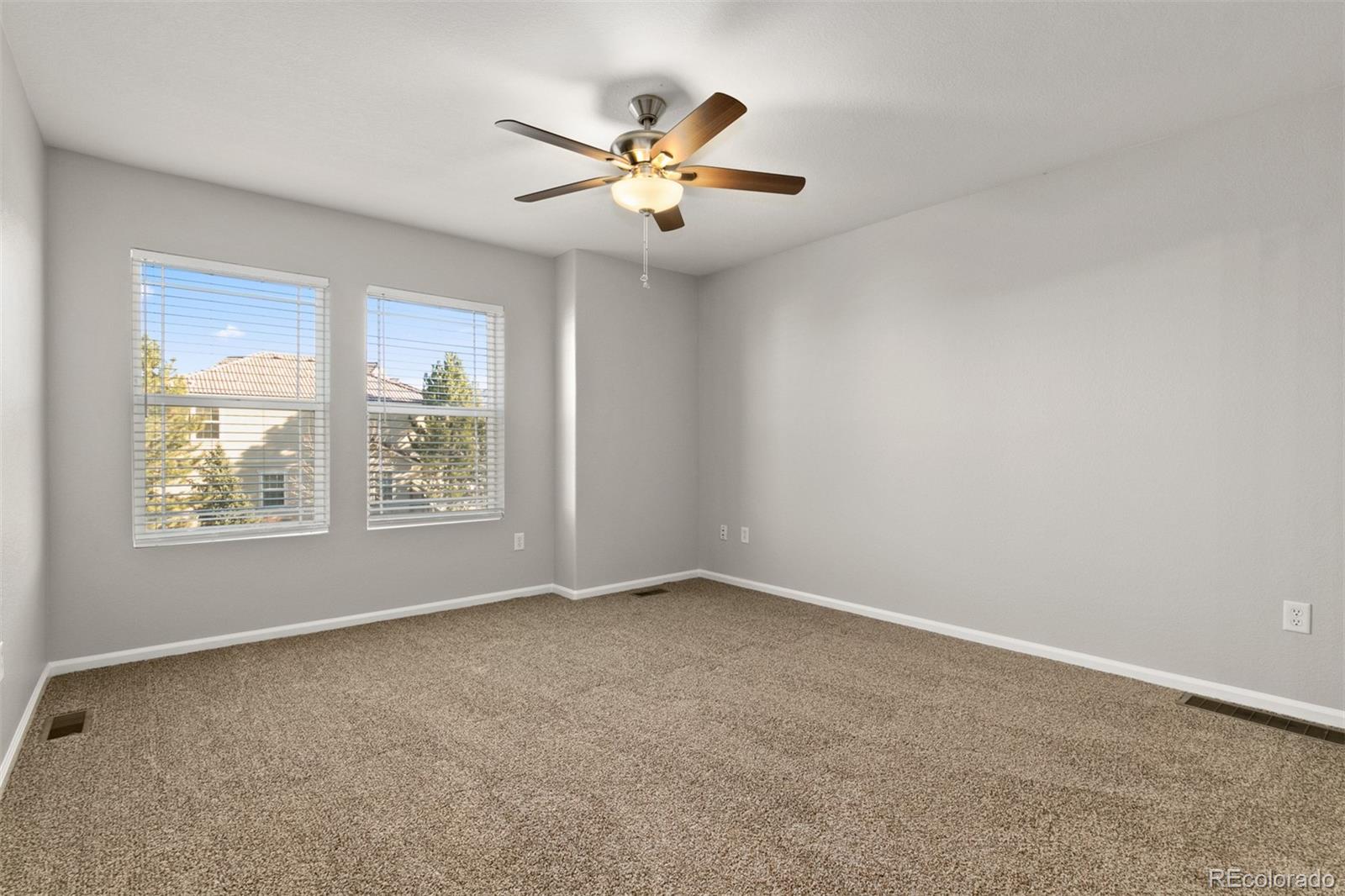 2562 Coach House Loop Castle Rock, CO 80109 - Photo 10 of 20 an empty room with window and ceiling fan