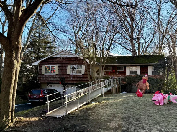 a front view of a house with yard and trees
