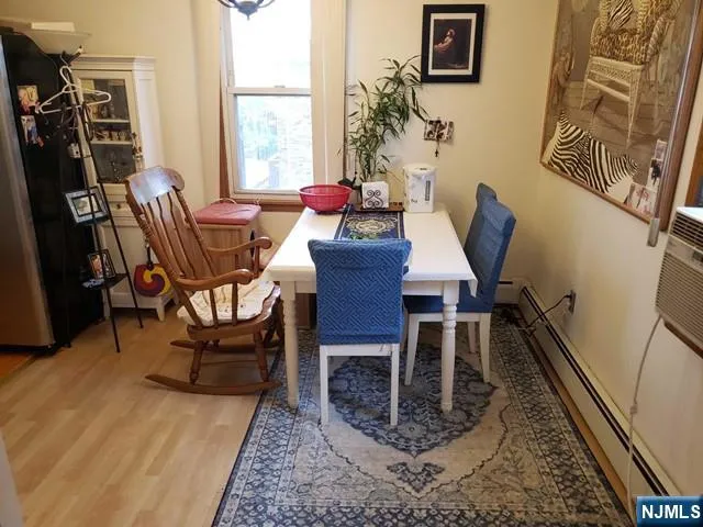 a dining room with furniture window and wooden floor