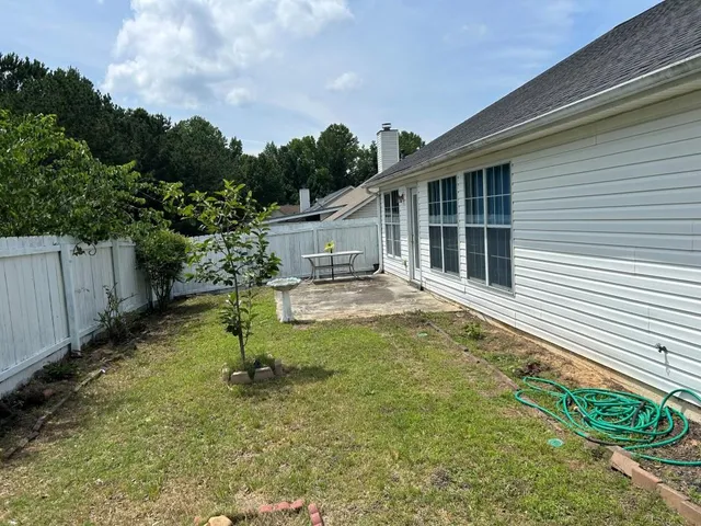 a backyard of a house with plants and tree