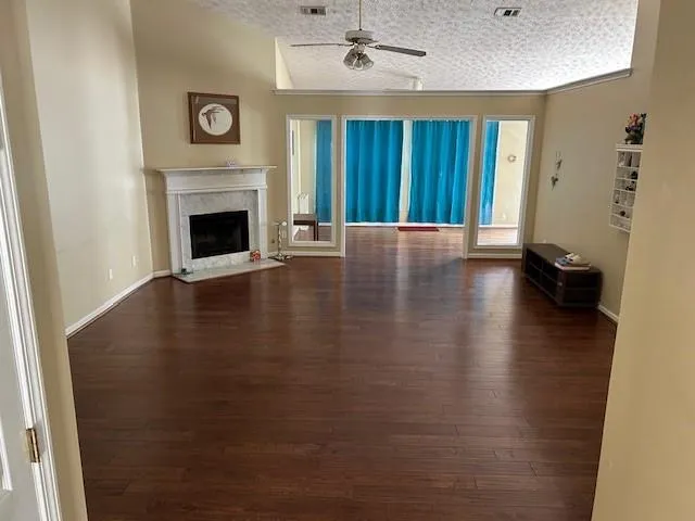 a view of a livingroom with wooden floor and a fireplace