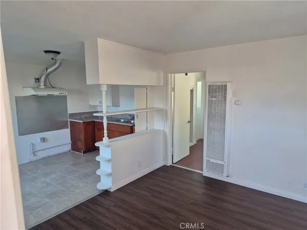 a view of a kitchen with wooden floor and electronic appliances