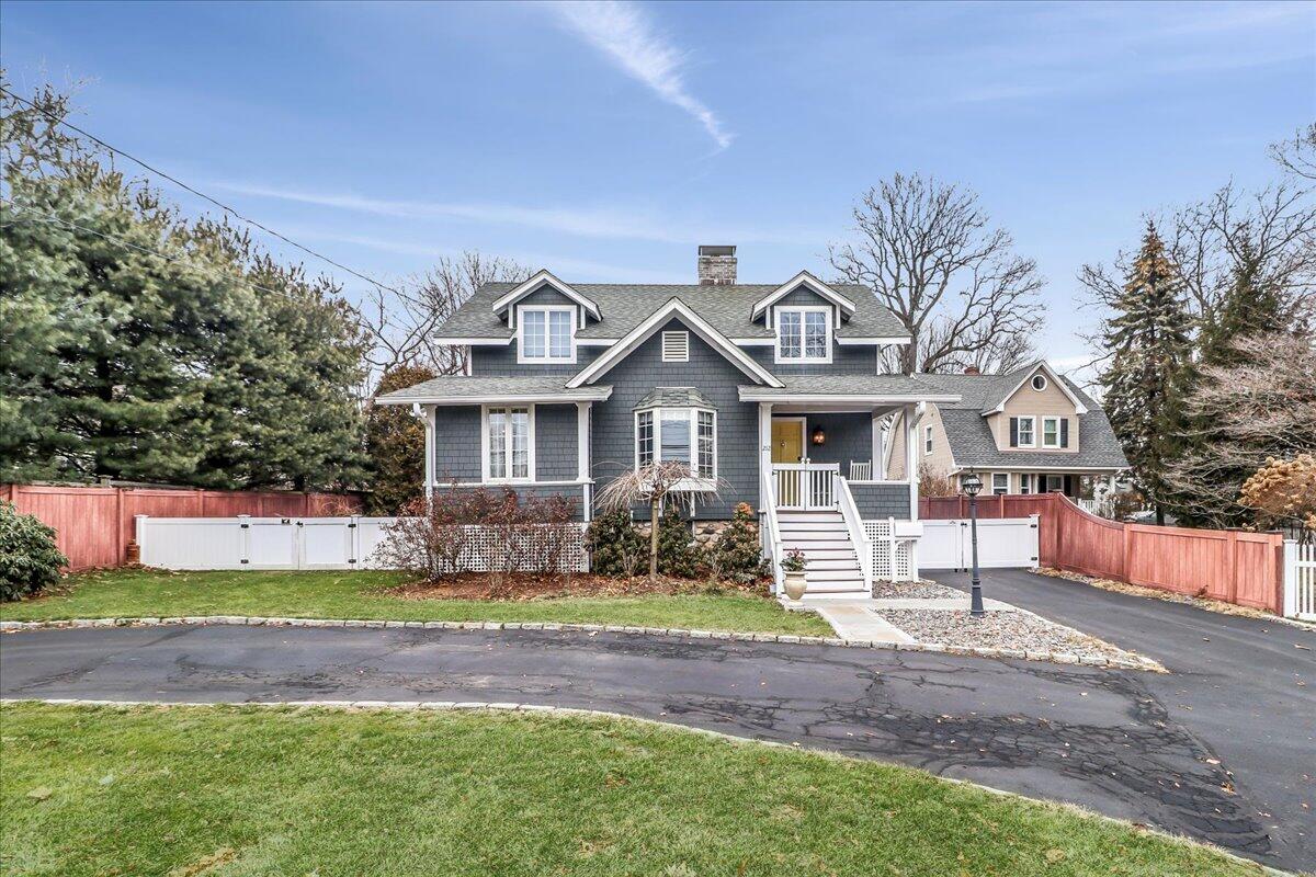 a front view of a house with a garden and trees
