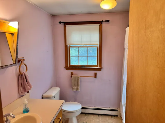 a bathroom with a toilet sink and mirror