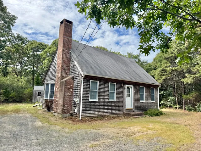 a view of a house with a tub and trees in the background