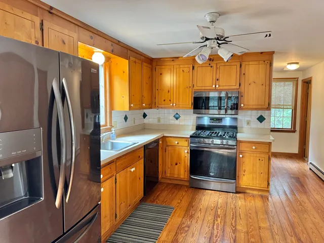 a kitchen with stainless steel appliances a stove refrigerator and a sink
