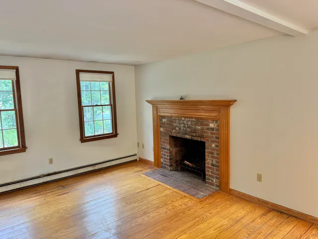wooden floor fireplace and windows in an empty room