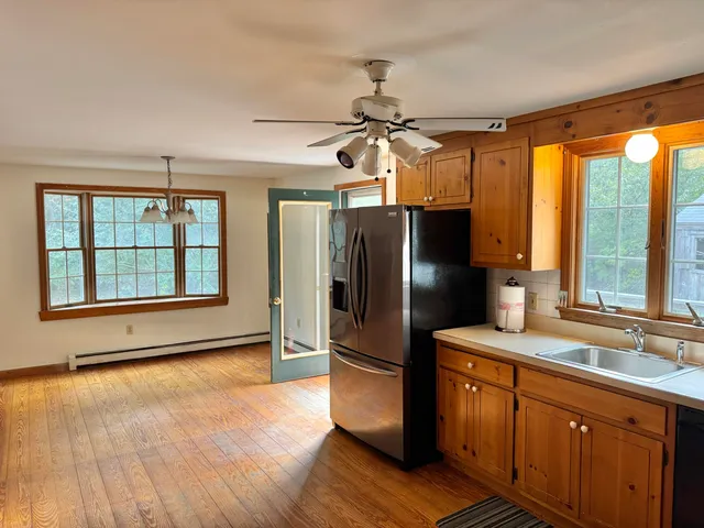 a kitchen with stainless steel appliances granite countertop a refrigerator a sink and a stove