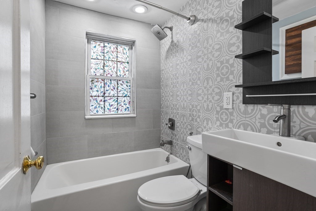 140 Lowell Street Lexington, MA 02420 - Photo 19 of 37 a bathroom with a sink a toilet a window and shower