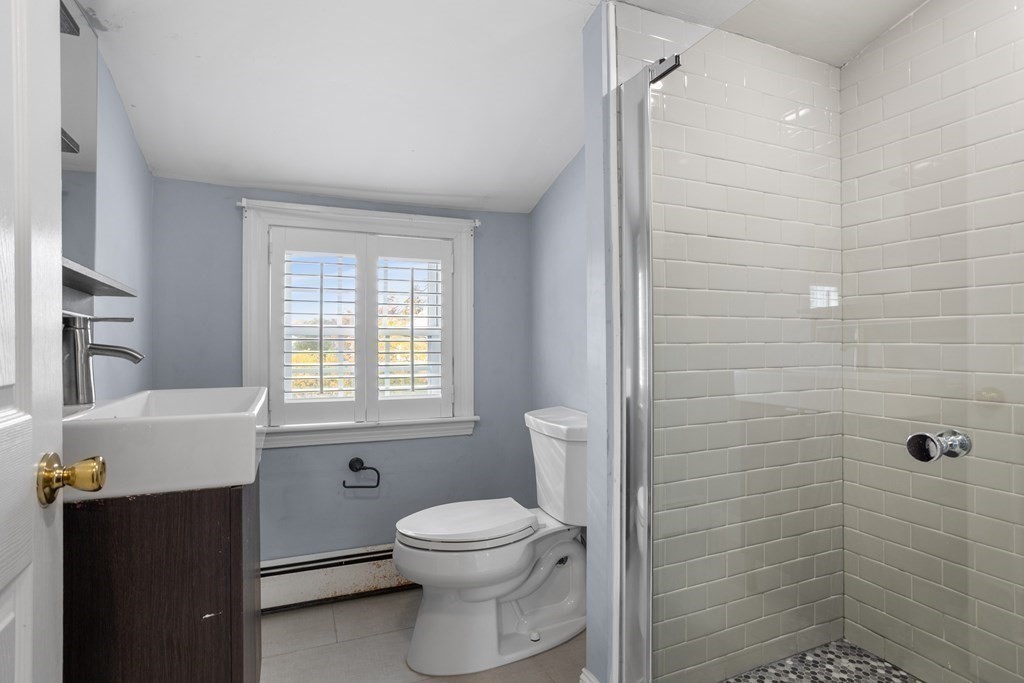 140 Lowell Street Lexington, MA 02420 - Photo 25 of 37 a bathroom with a toilet a sink a window and shower
