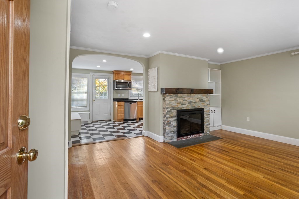 140 Lowell Street Lexington, MA 02420 - Photo 4 of 37 an empty room with wooden floor fireplace and windows