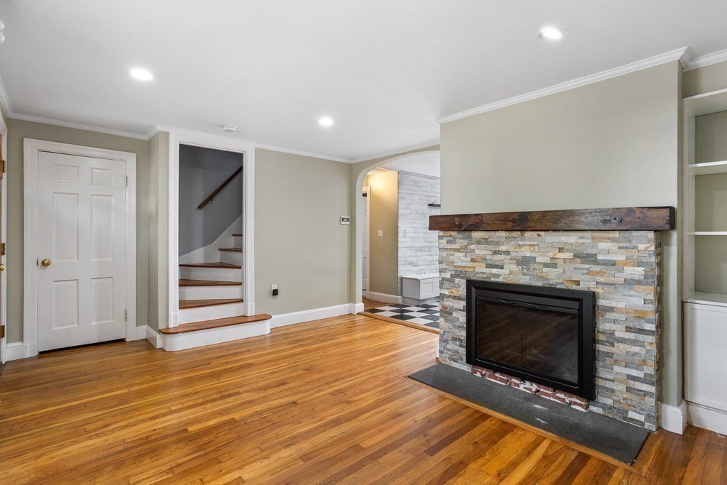 140 Lowell Street Lexington, MA 02420 - Photo 5 of 37 a view of an empty room with wooden floor fireplace and a window