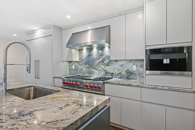 a kitchen with stainless steel appliances granite countertop a sink and cabinets