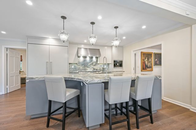 a kitchen with kitchen island a dining table chairs and wooden floor