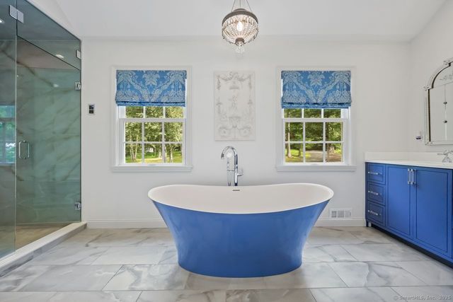 a white bath tub sitting in a bathroom next to a window