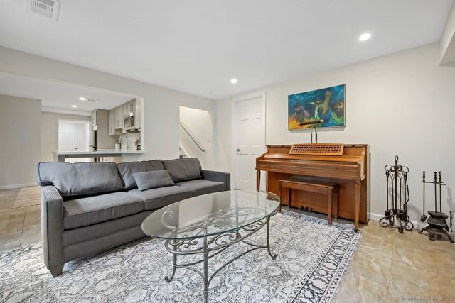 a living room with furniture a piano and a flat screen tv
