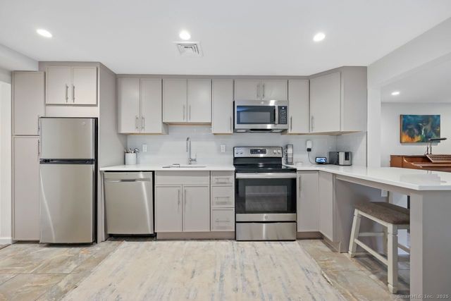 a kitchen with cabinets stainless steel appliances and a counter space