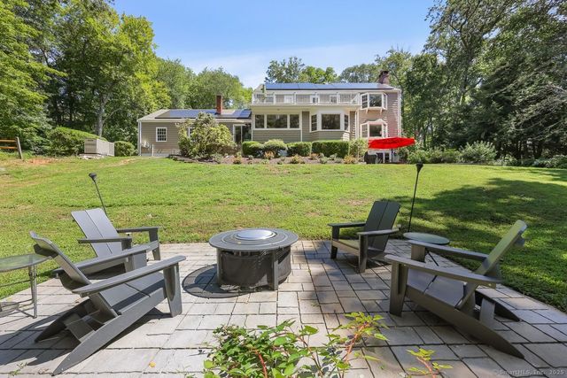 a view of a patio with table and chairs potted plants and a large tree