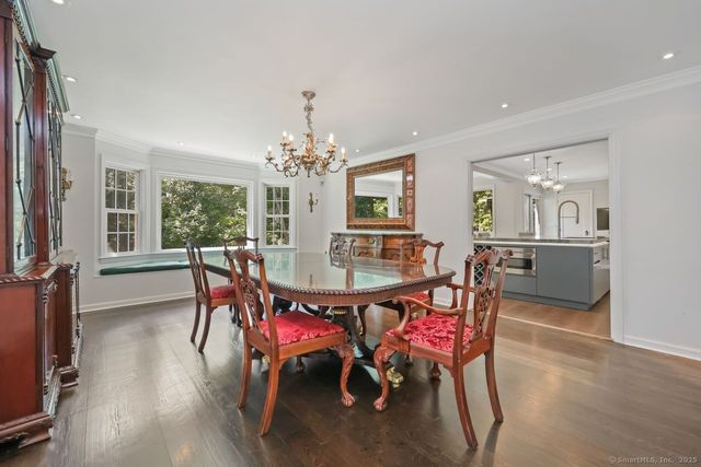 a dining room with furniture a chandelier and wooden floor