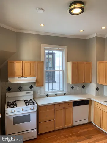 a kitchen with a stove a sink and a window