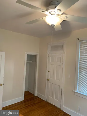 a view of a livingroom with a chandelier fan and wooden floor