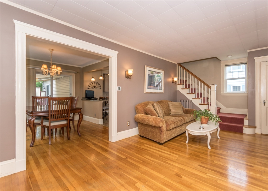 48 Bruce Road Waltham, MA 02453 - Photo 14 of 39 a living room with furniture and a dining table with wooden floor