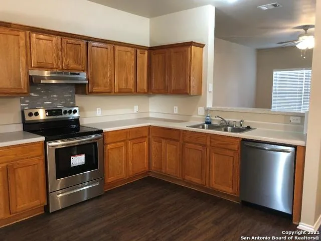 a kitchen with granite countertop wooden cabinets and a stainless steel appliances
