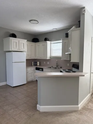 a kitchen with kitchen island a white cabinets and a sink