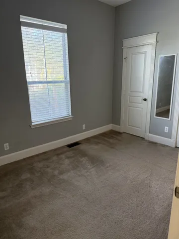 an empty room with a window and refrigerator