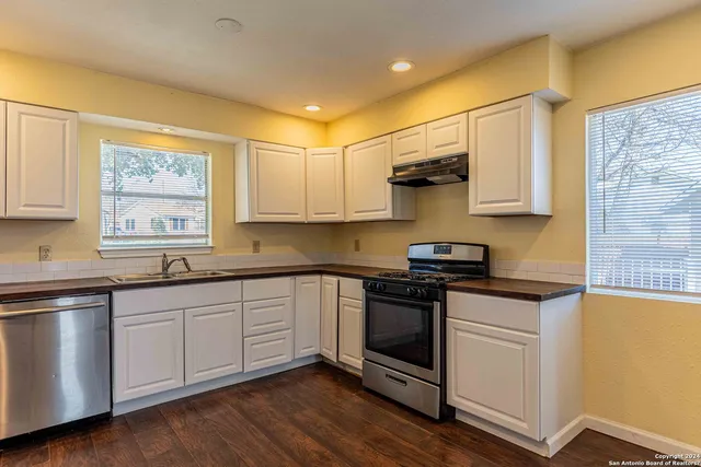 a kitchen with stainless steel appliances granite countertop a stove and a sink
