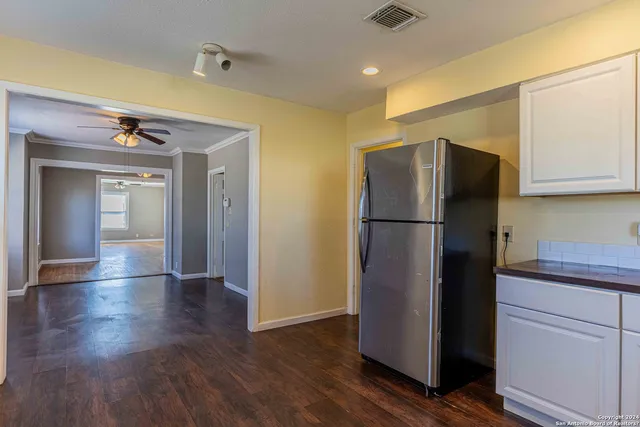 a kitchen with a refrigerator and a stove top oven