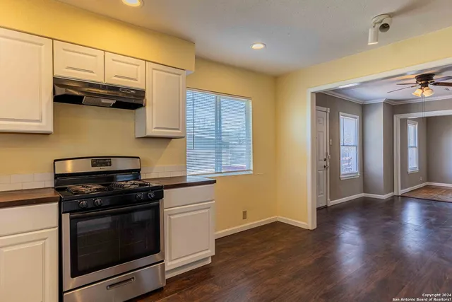 a kitchen with stainless steel appliances wooden floor sink and wooden cabinets
