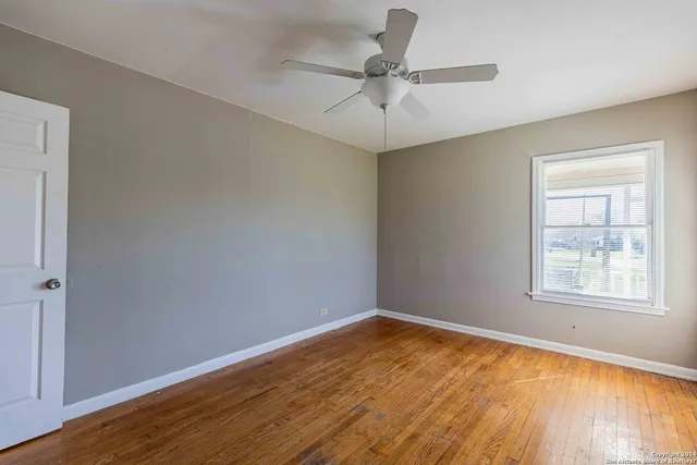 wooden floor in an empty room with a window