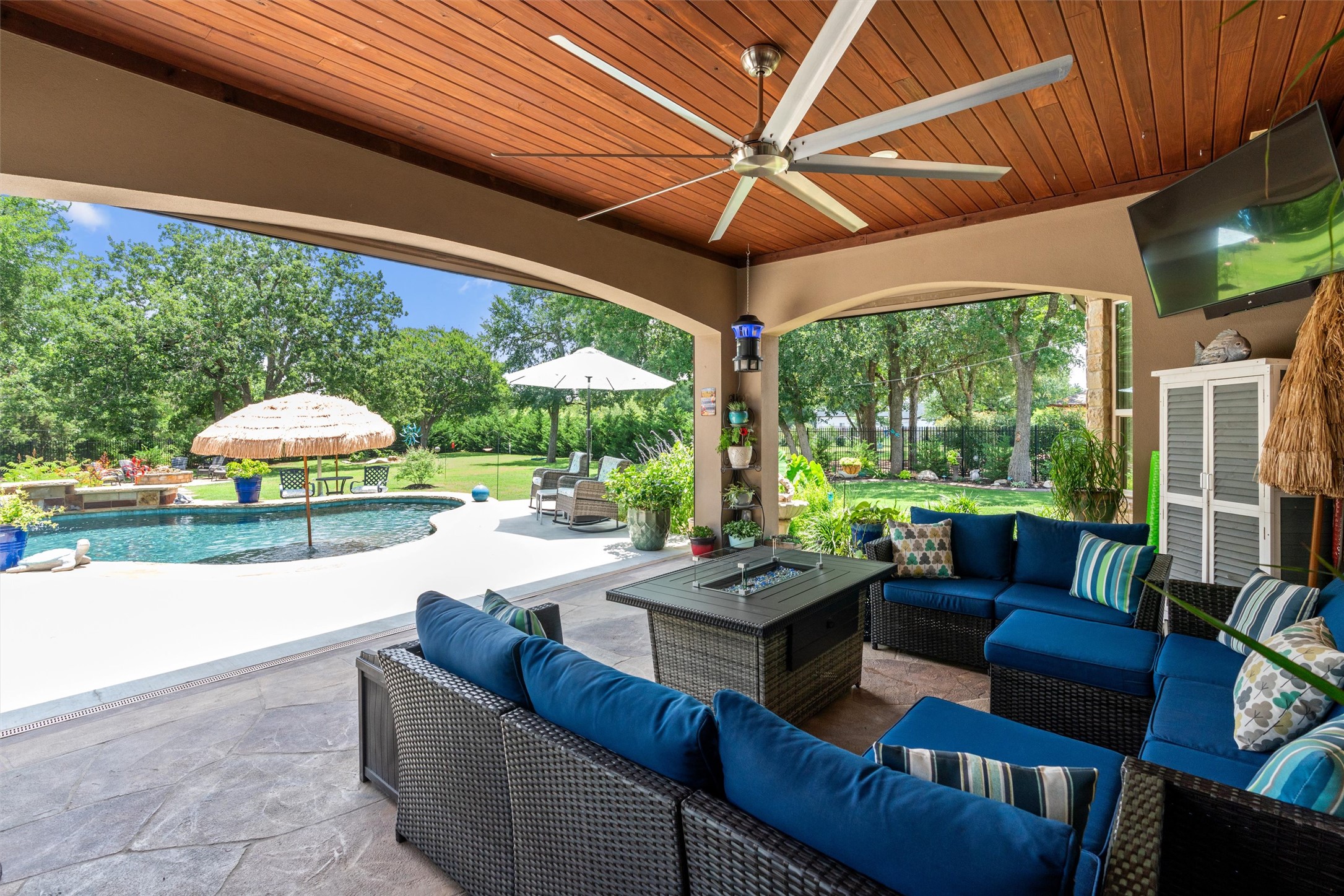 104 Adobe Cove Georgetown, TX 78633 - Photo 28 of 40 An inviting outdoor living space features comfortable seating with a fire pit, overlooking a private pool and green yard.