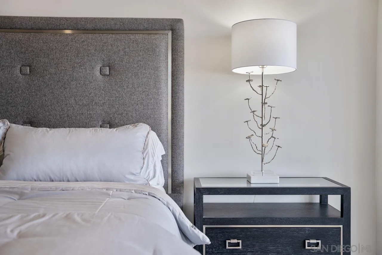 939 Coast La, Unit 16G La Jolla, CA 92037 - Photo 32 of 69 a bedroom with a bed and a chandelier