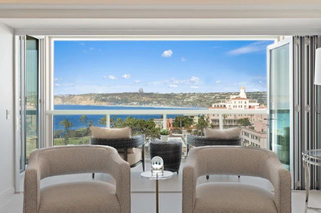 a living room with furniture a rug and a floor to ceiling window