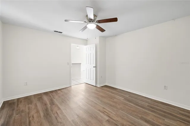 a view of an empty room with wooden floor