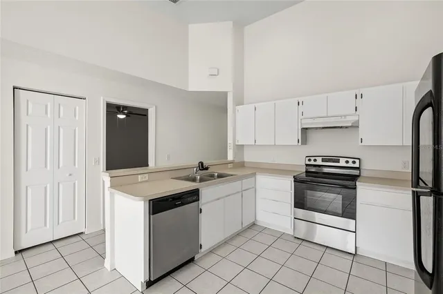 a kitchen with a stove sink and cabinets
