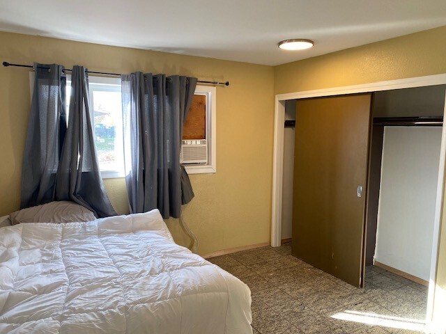 9016 Bong Loop, Unit B Moses Lake, WA 98837 - Photo 14 of 19 a bedroom with a large bed and wooden floor