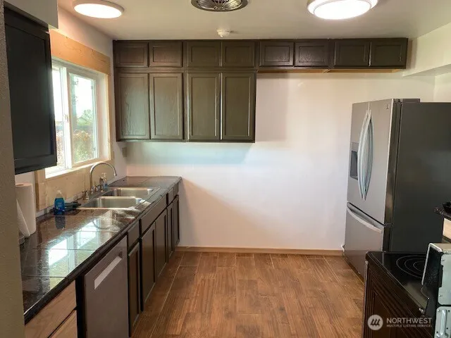 a kitchen with stainless steel appliances granite countertop a refrigerator and a stove