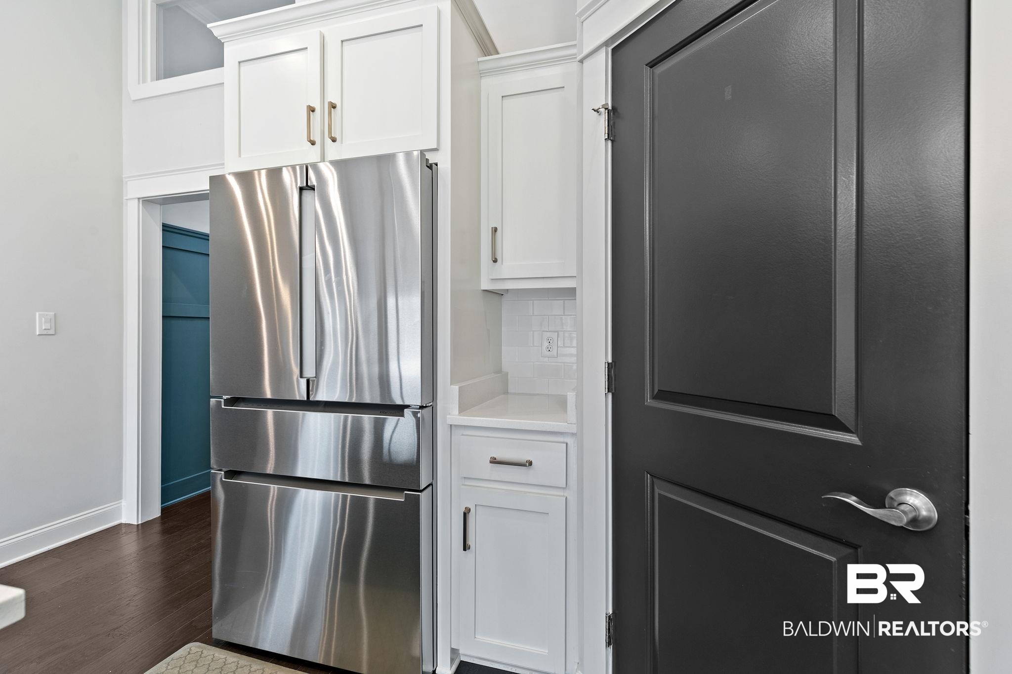 31654 Canopy Loop Daphne, AL 36527 - Photo 21 of 64 Kitchen featuring freestanding refrigerator, light countertops, white cabinetry, tasteful backsplash, and dark wood-type flooring