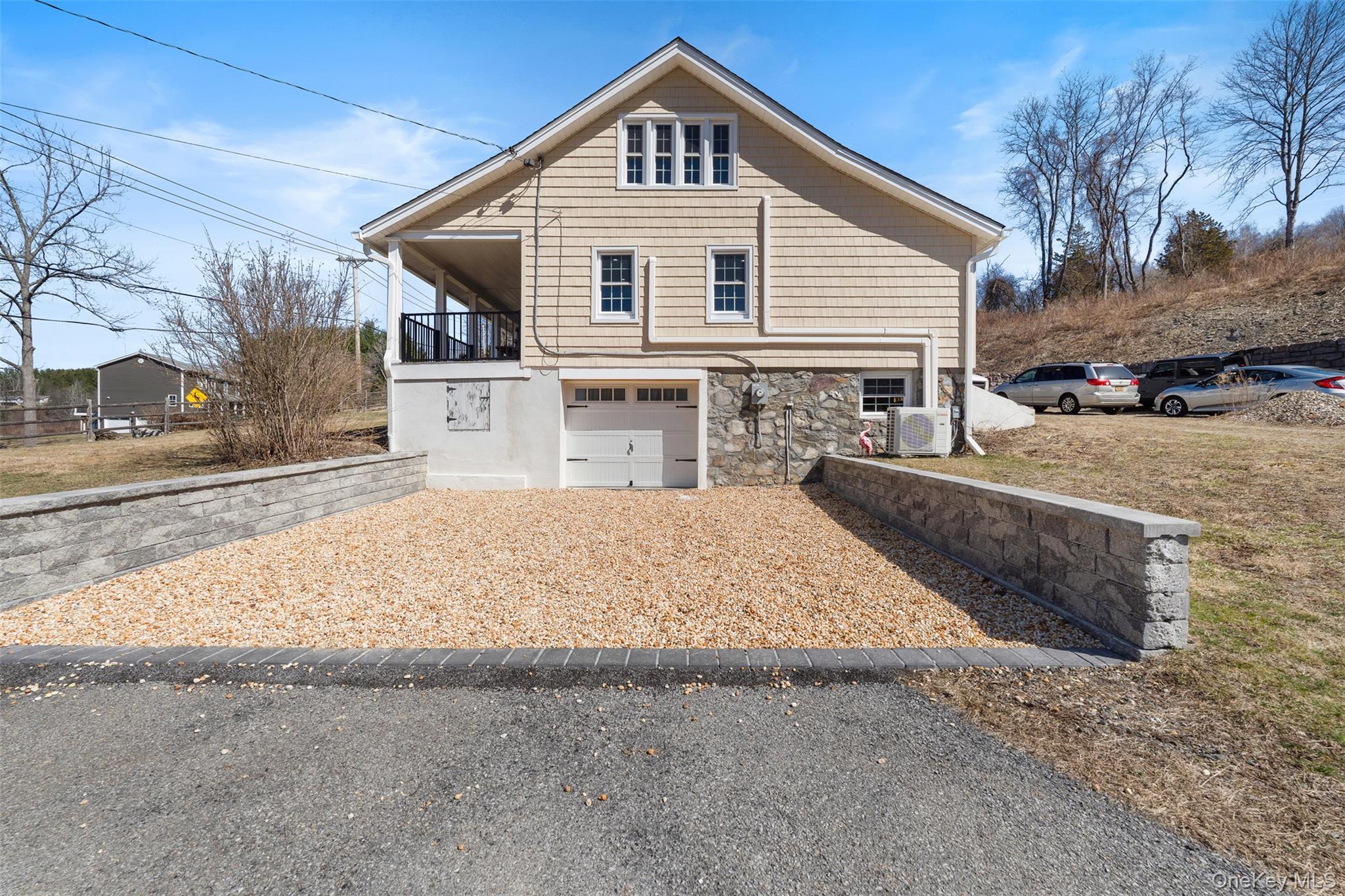 70 Barmore Road LaGrangeville, NY 12540 - Photo 28 of 47 View of home's exterior featuring stone siding, an attached garage, and gravel driveway
