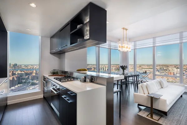 a kitchen with stainless steel appliances a table chairs and a view of living room