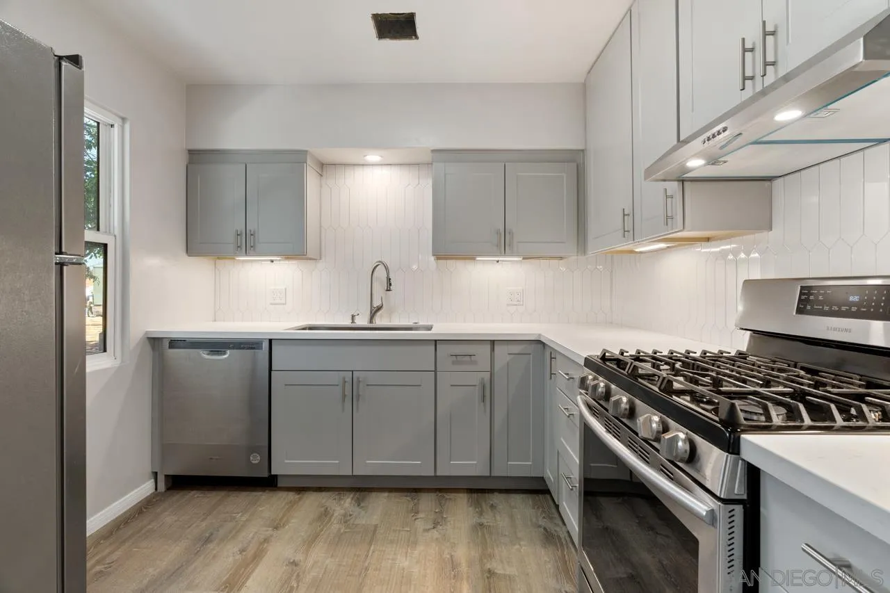 a kitchen with kitchen island white cabinets and stainless steel appliances