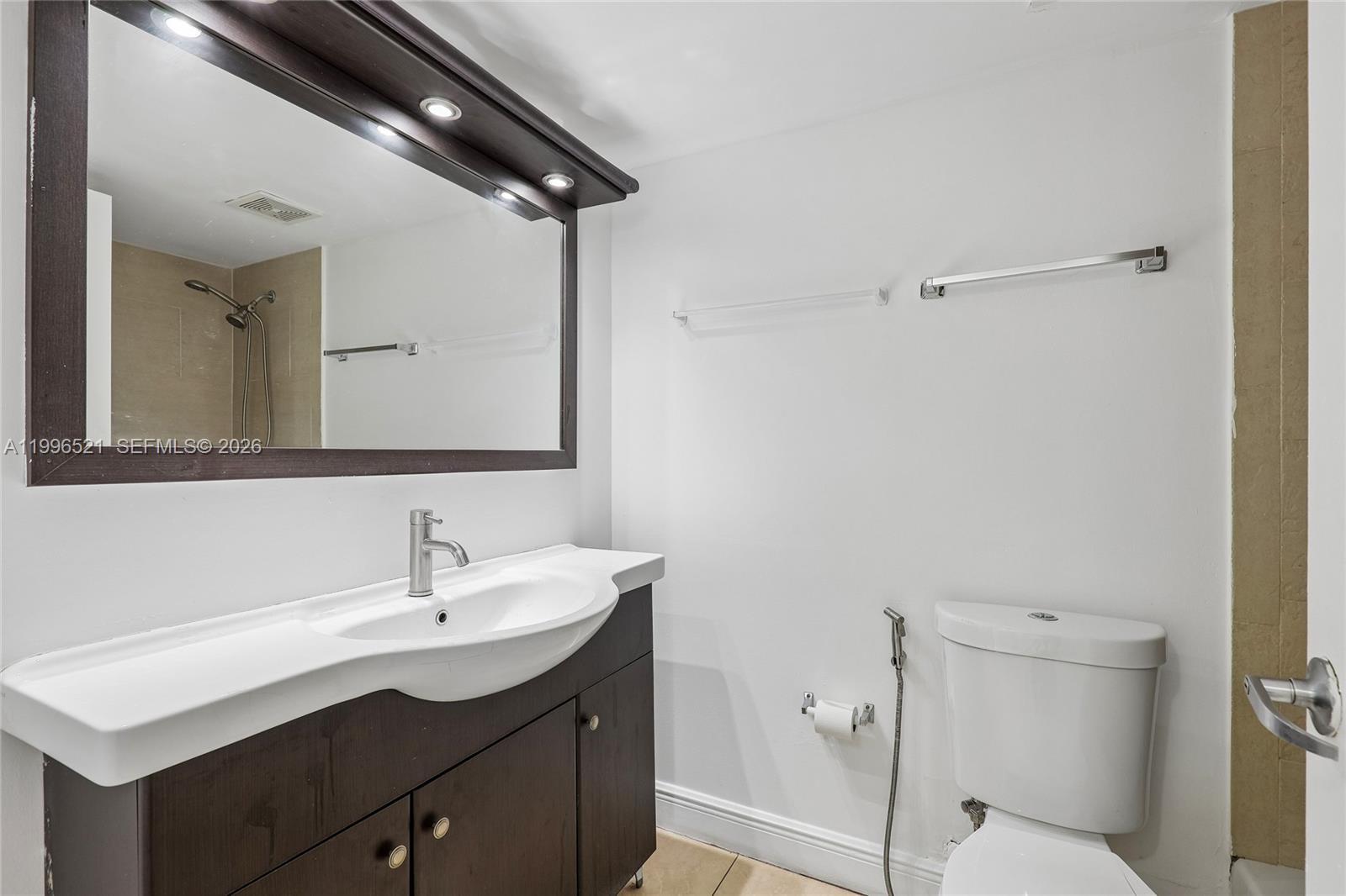 4137 Stirling Road, Unit 507 Dania Beach, FL 33314 - Photo 17 of 20 a bathroom with a sink a toilet a mirror and shower