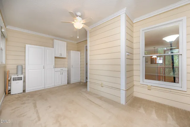 an empty room with closet and a chandelier fan