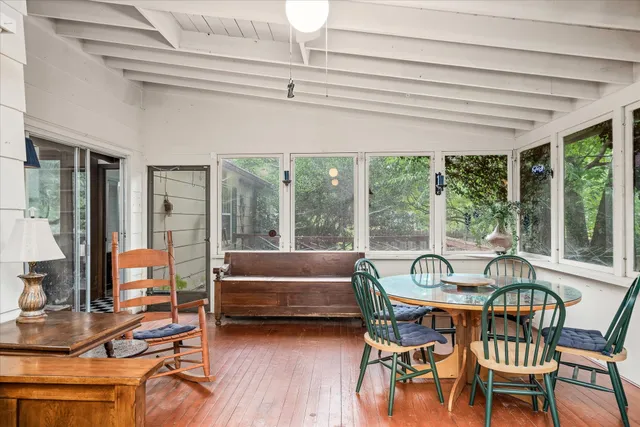 a dining room with furniture large windows and a chandelier