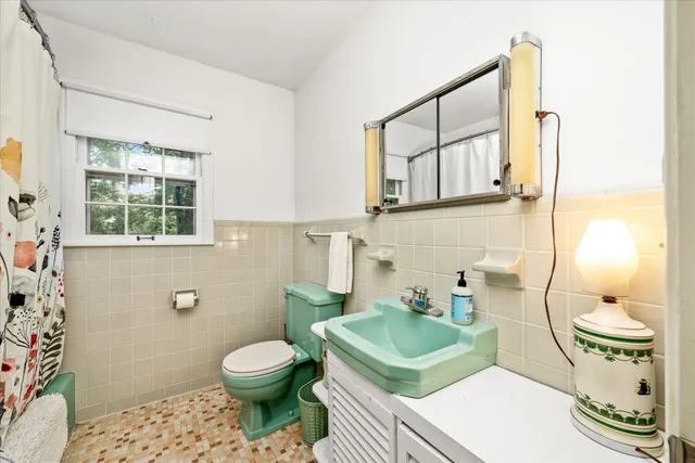 a bathroom with a sink a toilet and mirror