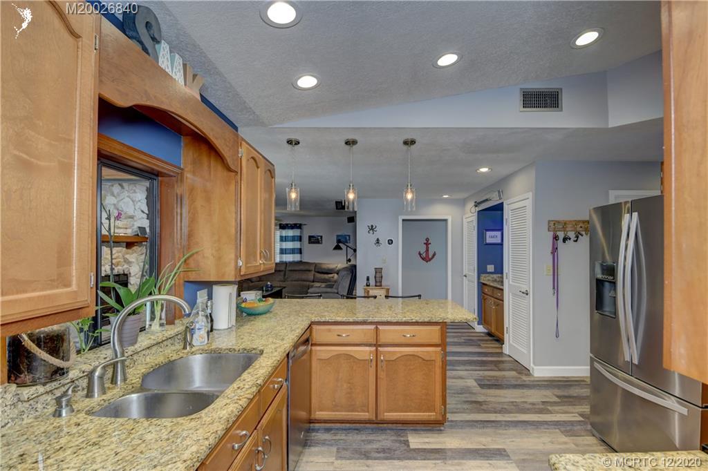 1654 Southwest 85th Terrace Stuart, FL 34997 - Photo 15 of 48 a large kitchen with stainless steel appliances kitchen island granite countertop a sink and cabinets